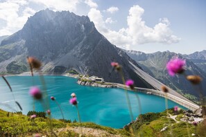 Escape to a serene mountain retreat surrounded by a tranquil lake and lush greenery, perfect for walking and hiking.