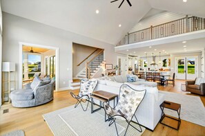A spacious living area with a staircase, a dining area, and a kitchen.