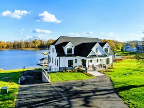 A two-story white house with a dark roof, a dock, and a grassy yard. - Lakefront Lake Anna, Boat Dock, Deck Views (Mineral)