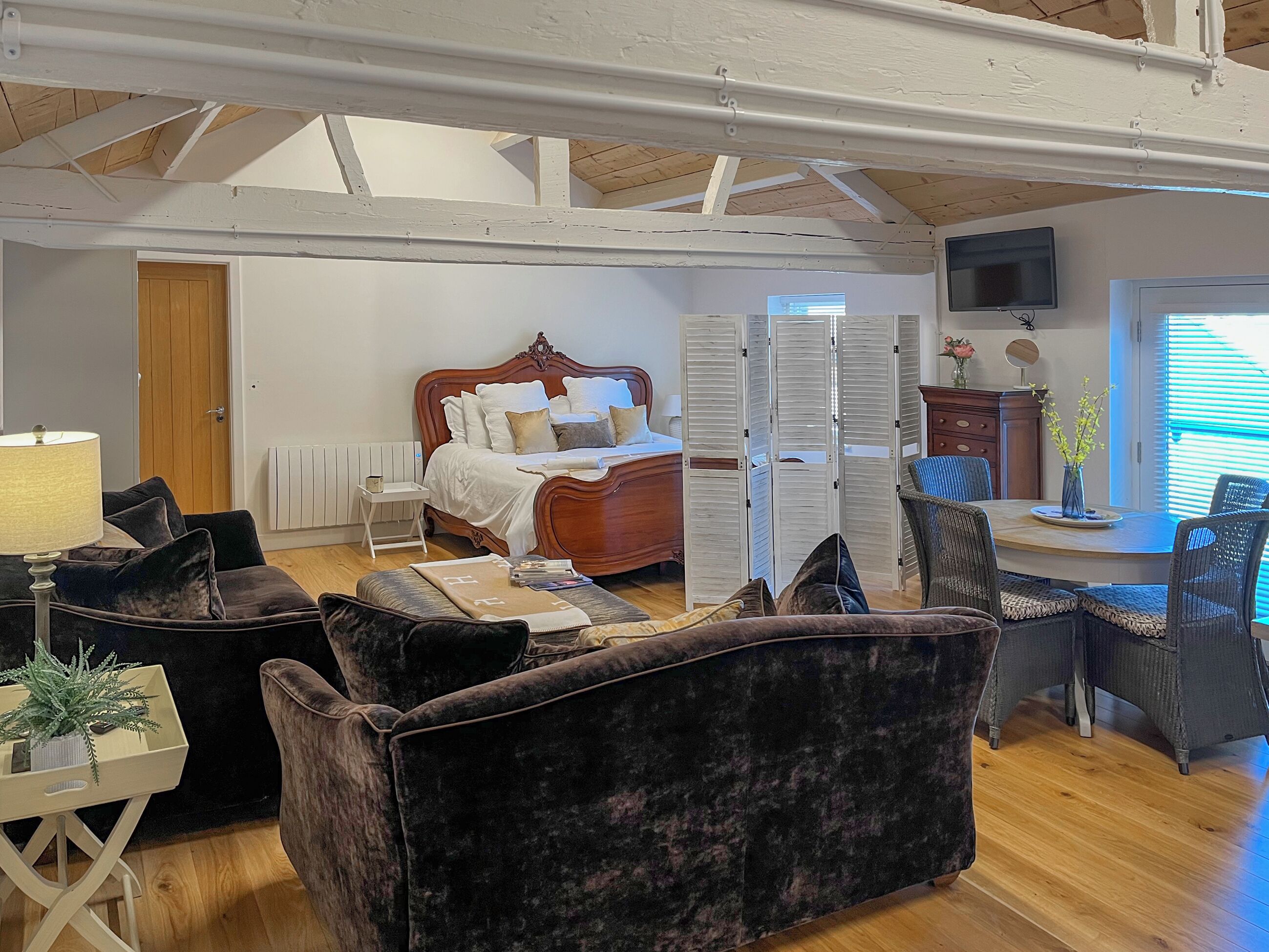 Een knus slaapkamer met een houten bed, een klein nachtkastje, een stoel en een bureau met stoel.