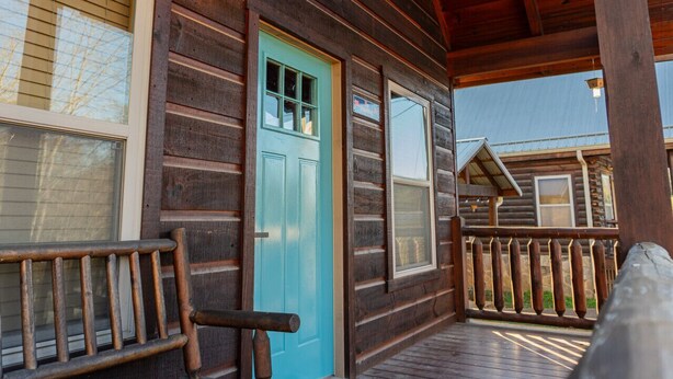A wooden cabin with a turquoise door, a porch with a wooden railing, and a light fixture above the door. - Lazy Lake Days • Fast Wifi • Roku TV • Free Firewood (Alpine)