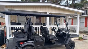 A golf cart parked in front of a house with a porch. - Ocean Lakes Cottage, Covered Patio, Grill and Beach! (Myrtle Beach)