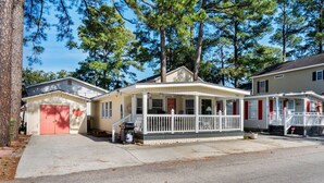 A single-story house with a porch, a garage, and a small driveway. - Ocean Lakes Cottage, Covered Patio, Grill and Beach! (Myrtle Beach)