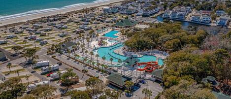 Vista aerea di un resort costiero con diverse piscine, un parco acquatico e una spiaggia.