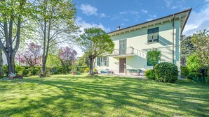 Ein zweistöckiges Haus mit gepflegtem Rasen und einer kleinen Terrasse.