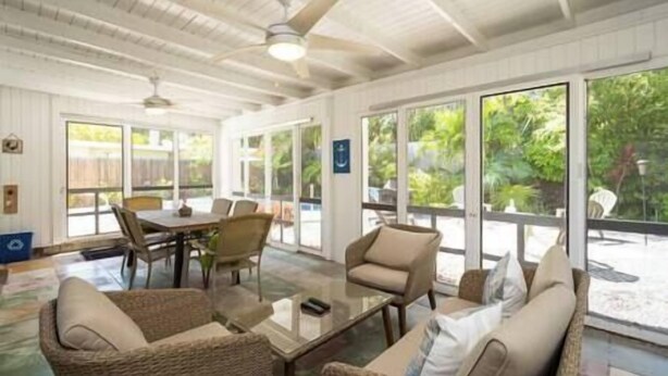 A spacious indoor area with a ceiling fan, a dining table with chairs, and a seating area with sofas and a coffee table. - Plumeria Paradise, Your Tropical Retreat Close to the Beach (Key West)