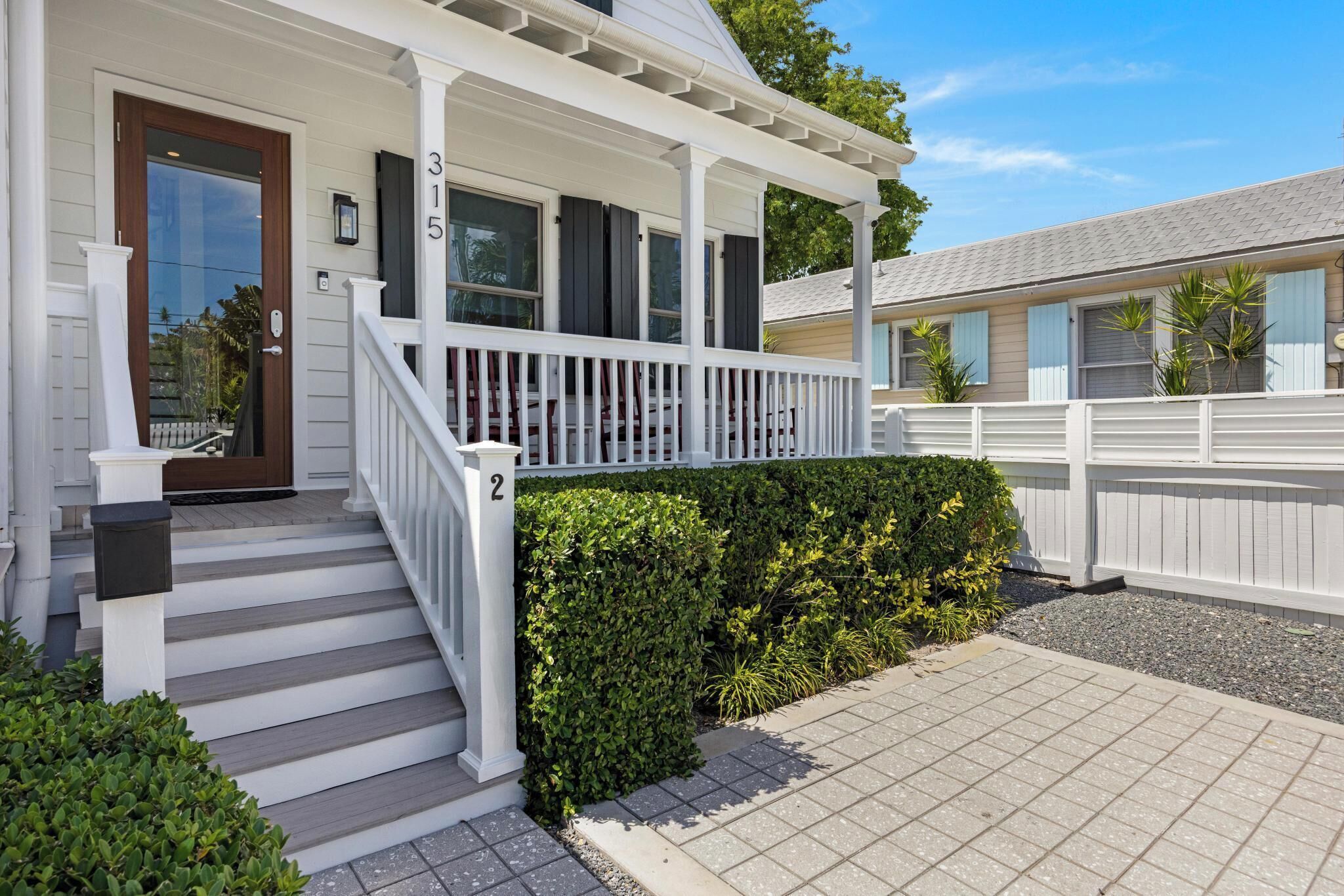 A two-story house with a porch, steps, and a mailbox.