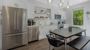 A modern kitchen with stainless steel appliances, white cabinetry, and pendant lighting. - Southern Skies, Stylish Home in Old Town Key West (Key West)