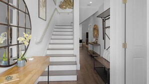 A modern interior with a staircase, wooden console table, and decorative items. - Southern Skies, Stylish Home in Old Town Key West (Key West)