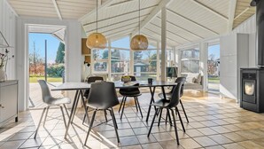 Una cocina amplia con una gran mesa de comedor, sillas modernas y una estufa empotrada.