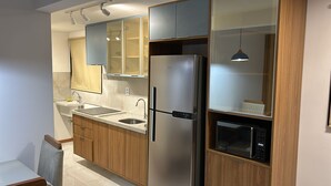 Une cuisine moderne équipée d’un réfrigérateur en acier inoxydable, d’un four à micro-ondes et d’un évier.