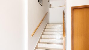 A staircase with a wooden handrail and a white door at the bottom. - Beautiful apartment in Omis with lake view (Omis)