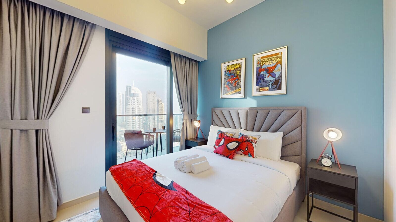 Habitación de hotel con una cama grande, vista a la ciudad y decoración temática de Spider-Man.