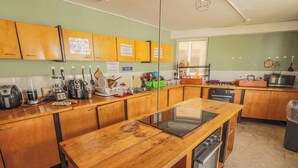Una cocina con armarios de madera, estufa integrada y diversos electrodomésticos.