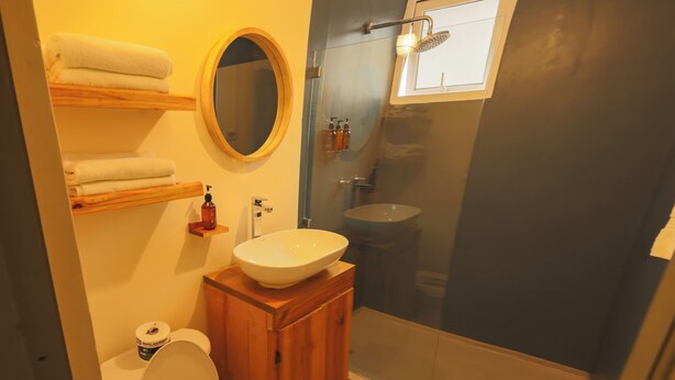 A bathroom with a toilet, sink, and shower. - Edificio Bola de Oro (Panama City)