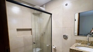 Une salle de bain moderne dotée d’une douche à parois de verre, de toilettes et d’un lavabo avec un plan de travail en granit.