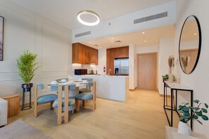 Un appartement moderne comprenant un coin repas, une cuisine et un espace de vie.