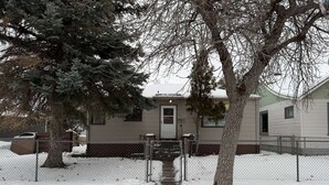 A snow-covered pathway leading to a house with a front door and a mailbox. - Newly remodeled 2-bedroom house with WiFi, conveniently located in Great Falls (Great Falls)