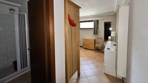 A hallway with a wooden door, a small wooden cabinet, and a white cabinet. - Short periods Reggio Emilia center  (Reggio Emilia)