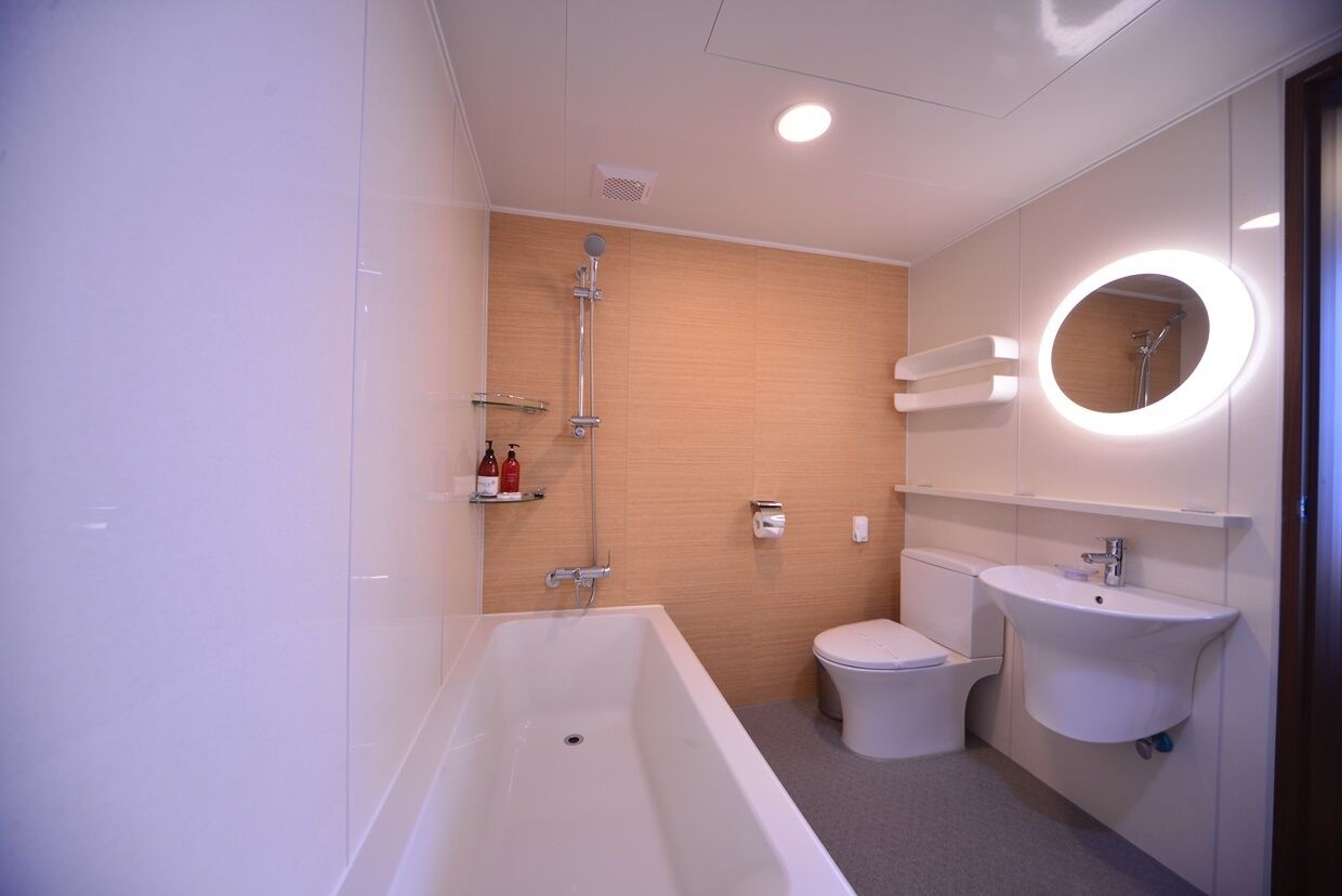 A modern bathroom with a bathtub, toilet, and sink.