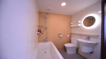 A modern bathroom with a bathtub, toilet, and sink.