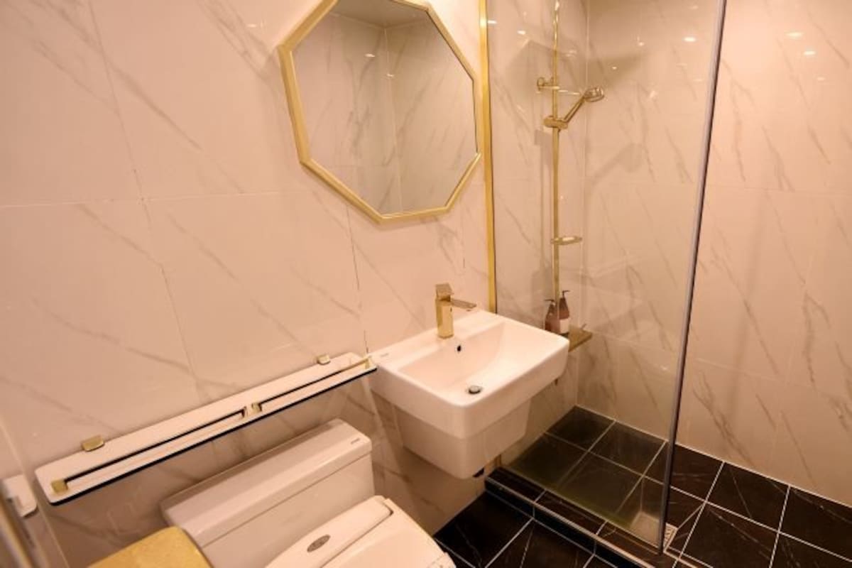 A bathroom with a white sink, a mirror, and a shower.