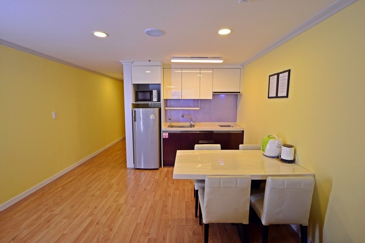 A compact kitchen with a refrigerator, microwave, and sink.