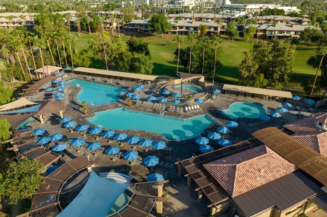 A resort with multiple swimming pools, sun loungers, and umbrellas.