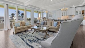 A spacious living room with a large window, a ceiling fan, and a view of the outside. - Ocean View, Gulf Access, Close to Beach, Private heated Pool - Island Waters  - Roelens (Fort Myers Beach)