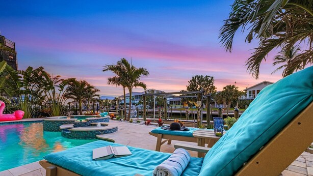 A poolside lounge area with lounge chairs and a pool. - Ocean View, Gulf Access, Close to Beach, Private heated Pool - Island Waters  - Roelens (Fort Myers Beach)