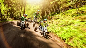 Un grupo de personas en un sendero para motos de tierra, rodeado de un bosque denso.