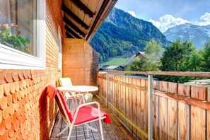 A wooden balcony with a view of a mountain landscape. - Familiennest Zentral (Brand)