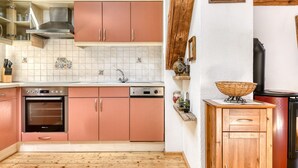A kitchen with pink cabinets, a stainless steel oven, and a dishwasher. - Chalet Fischer in B Rserberg (Buerserberg)