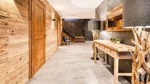 Ein modernes Interieur mit Holzwänden, einer Treppe, einem Schreibtisch mit Pflanzen und einem großen Spiegel.