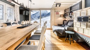 Un salon chaleureux avec une table à manger en bois, un canapé et une cheminée.