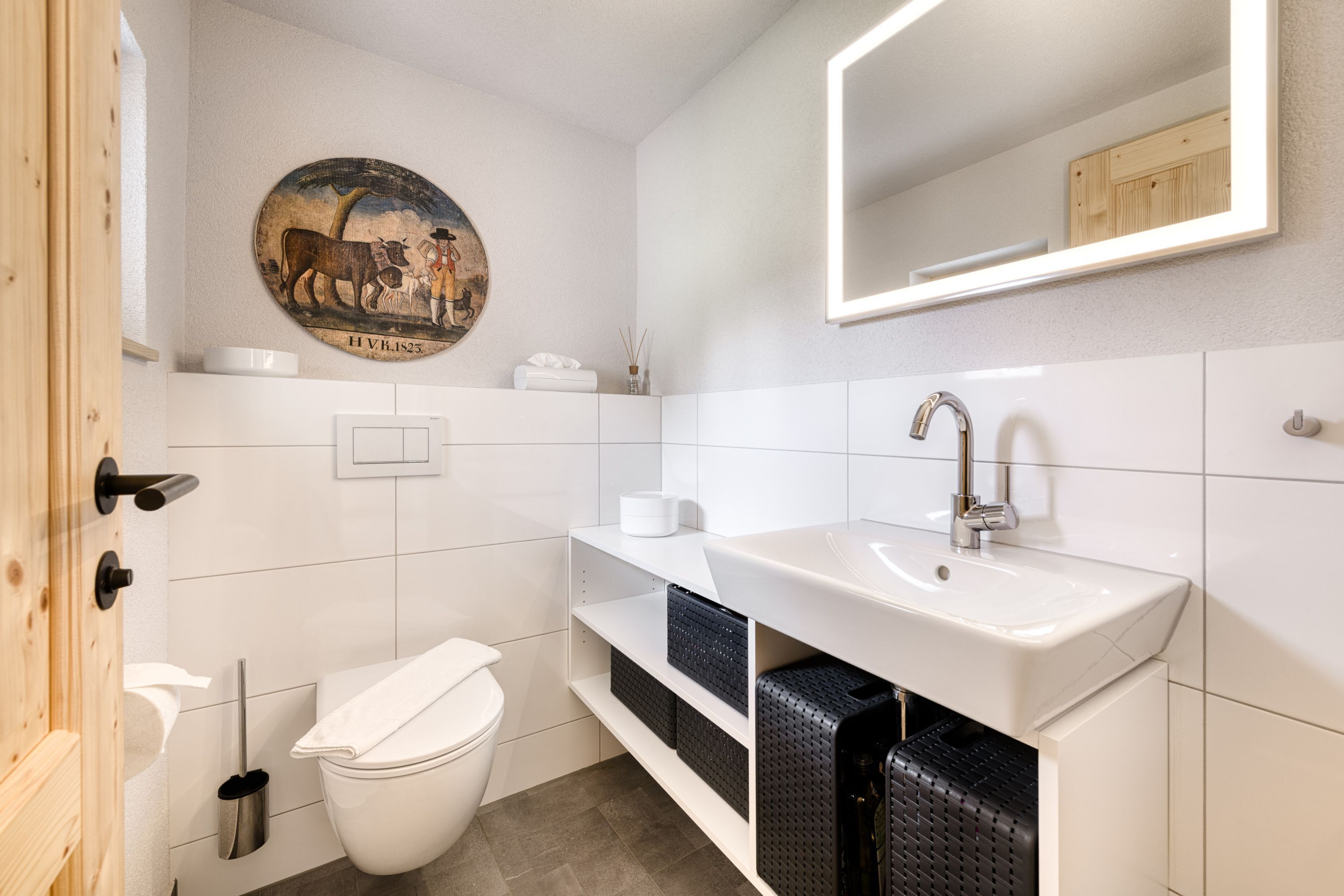 A modern bathroom with a toilet, sink, and mirror.