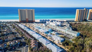 A coastal hotel complex with multiple buildings, a beach, and a parking area. - PCB Beach Retreat with Pool and Private Balcony (Panama City Beach)