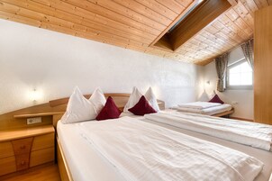 Un dormitorio con dos camas y cabeceras de madera, además de un techo inclinado.