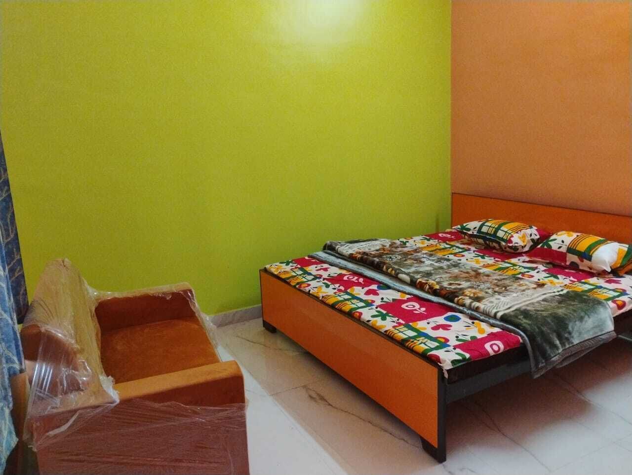 Una habitación con una cama, una mesita de noche de madera y un objeto envuelto en plástico en el suelo.