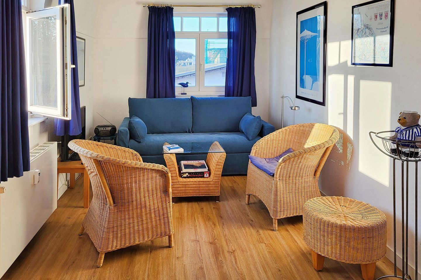 A living room with a sofa, two wicker chairs, a coffee table, and a small side table.