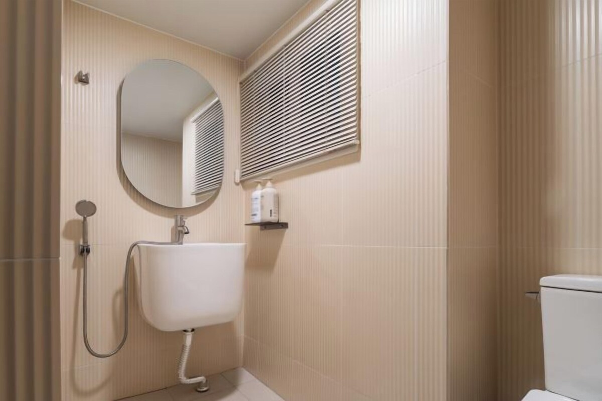 Une salle de bain avec un lavabo blanc, un miroir et des toilettes.