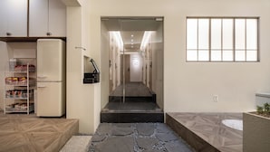 Un couloir d’hôtel moderne avec un comptoir d’enregistrement, un réfrigérateur et une étagère à collations.