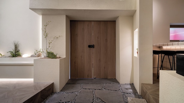 Un intérieur moderne avec une porte en bois, un chemin de pierre et un design minimaliste.