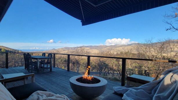 A deck with a fire pit, seating, and a view of the mountains. - Hot tub | Sauna |Firepit |Sleeps 6! (Ashland)
