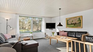Un salon moderne avec un canapé, une table basse et un téléviseur.
