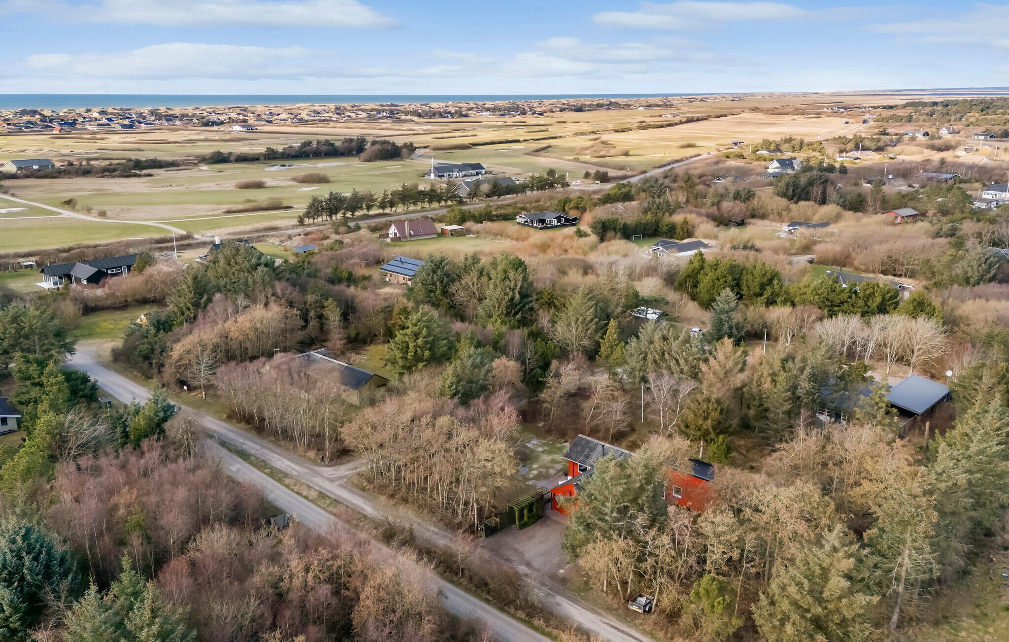 An aerial view of a rural area with scattered houses, roads, and fields.