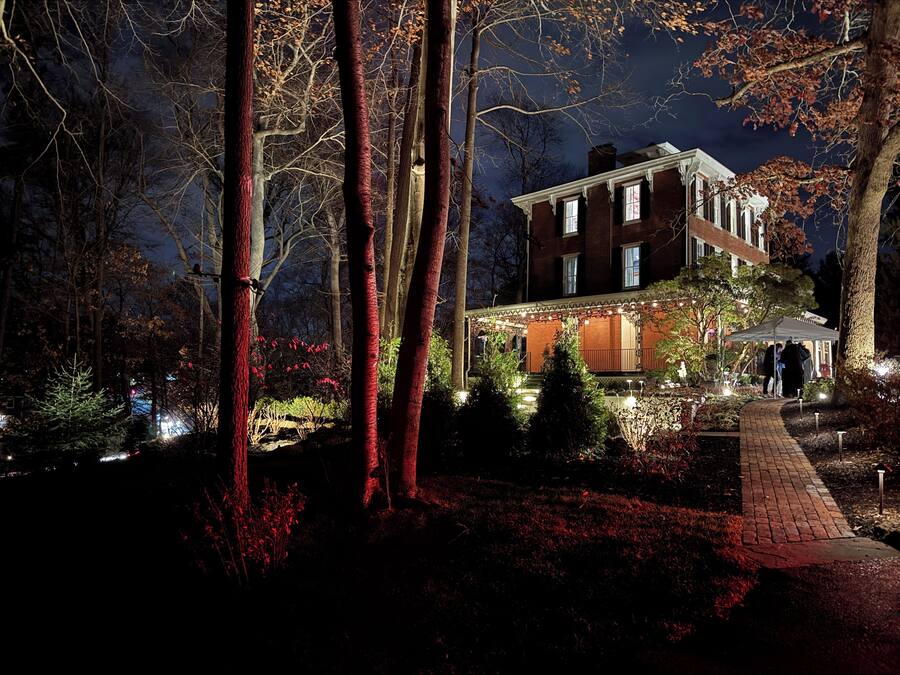 A two-story building with a brick facade and a wrap-around porch.