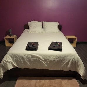 A bed with a white bedspread, two towels on the bed, and wooden nightstands with lamps. - Country house near the spa (Vandenesse)