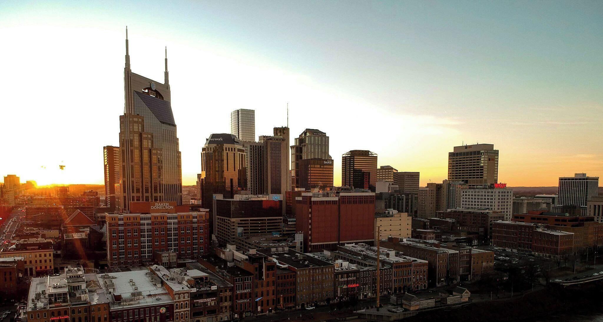 A cityscape with a variety of building heights and architectural styles, including a prominent skyscraper with a unique design.
