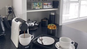 A kitchenette with a coffee maker, tea selection, and coffee capsules on shelves. - 3 Bdroom two-level townhouse close to Devonport  (Auckland)